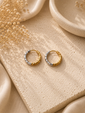 Aretes argolla bicolor dorado y plateado con textura facetada sobre piedra