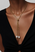Collar lariat dorado con perlas colgantes usado en modelo