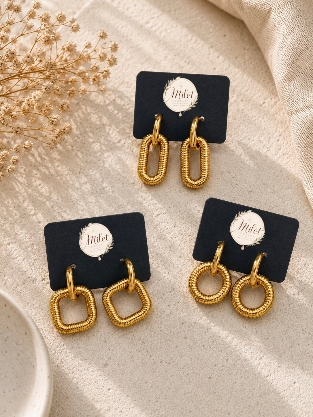 Aretes colgantes dorados con textura en tres formas: circular, cuadrada y eslabón