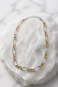 Collar cadena bicolor eslabones alternados dorado y plateado sobre mármol blanco