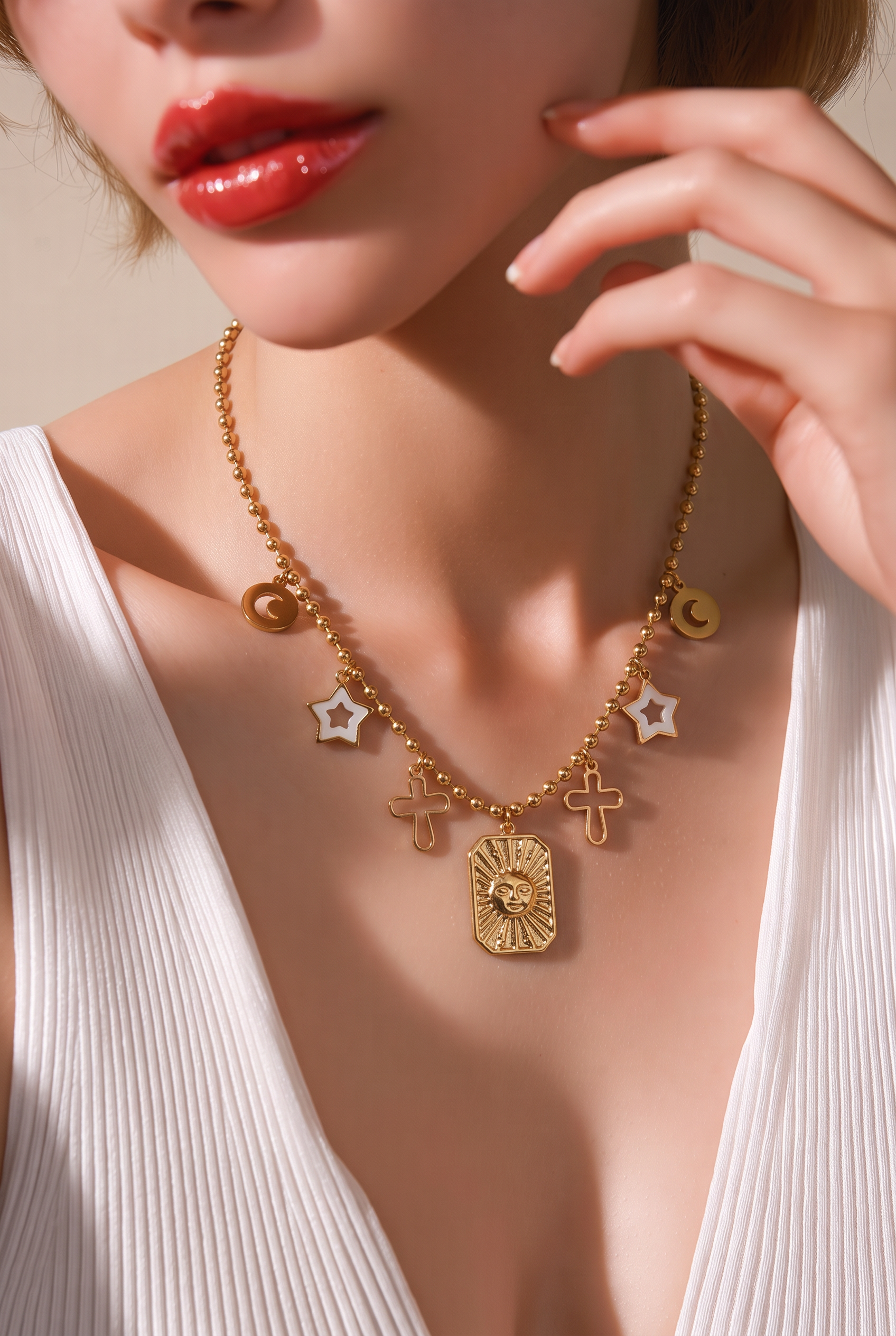 Collar dorado con charms celestiales: lunas, estrellas nacaradas, cruces y medallón del sol usado por modelo