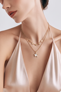 Collar doble cadena dorada con estrellas y colgante nacarado usado por modelo